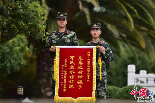 意带着一面写有"危急之时伸援手,军民鱼水情谊深"字样的锦旗来到支队