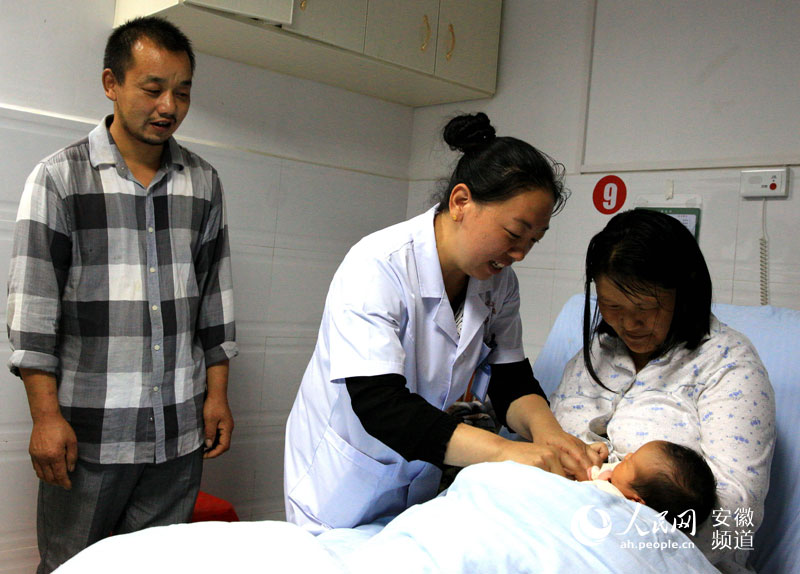 金寨县天堂寨镇中心卫生院妇产科护士江慧到病房查看了解新生儿情况。（汪诚 摄影）