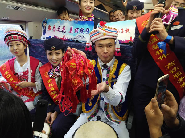 工作人员在D4208次列车上展示赠送给乘客的云南民族特色饰品