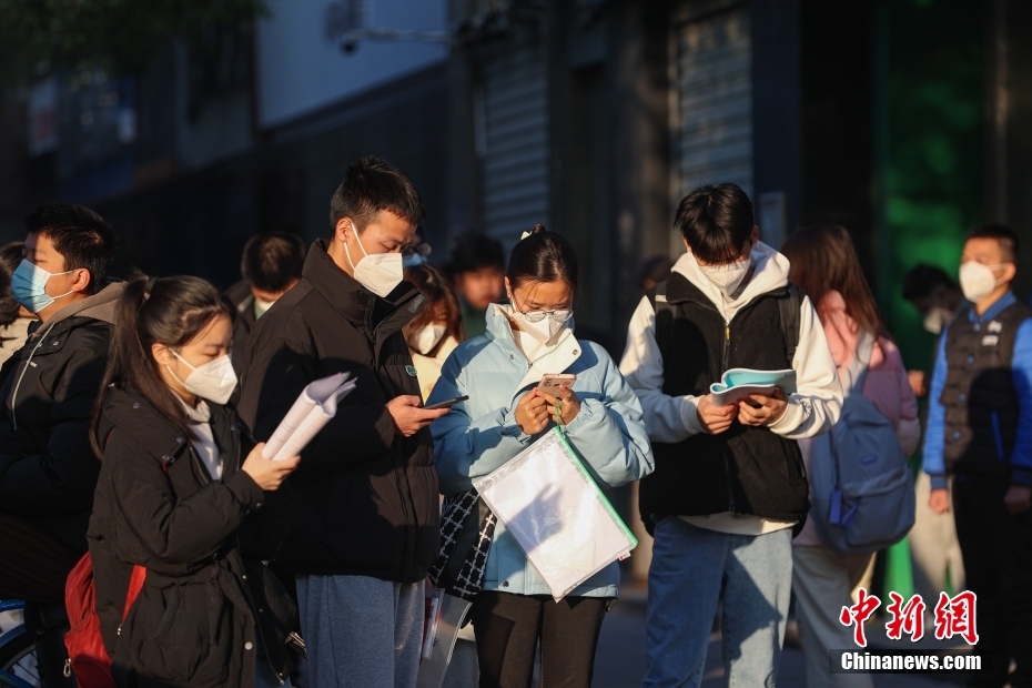 1月8日，江西南昌市第二十八中学考点外，几名考生在复习。当日，中央机关及其直属机构2023年度考试录用公务员公共科目笔试举行。<a target='_blank' href='/'>中新社</a>记者刘力鑫摄
