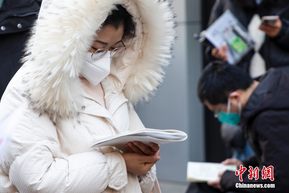 1月8日，郑州，河南省商务中等职业学校考点外，考生入场前复习。当日，中央机关及其直属机构2023年度考试录用公务员公共科目笔试举行。<a target='_blank' href='/'>中新社</a>发程航摄