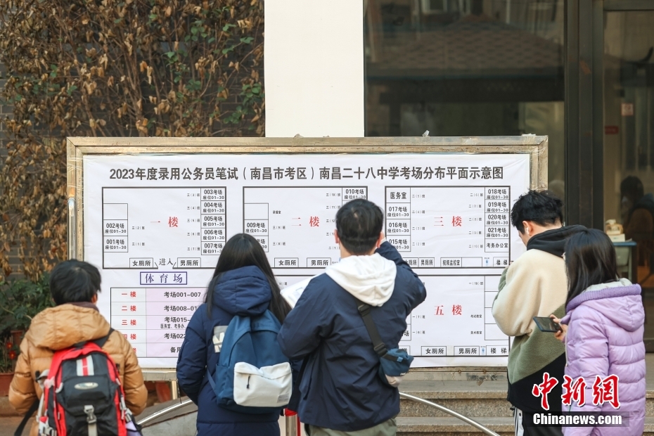 1月8日，江西南昌市第二十八中学考点，几名考生在察看考场安排表。当日，中央机关及其直属机构2023年度考试录用公务员公共科目笔试举行。<a target='_blank' href='/'>中新社</a>记者刘力鑫摄