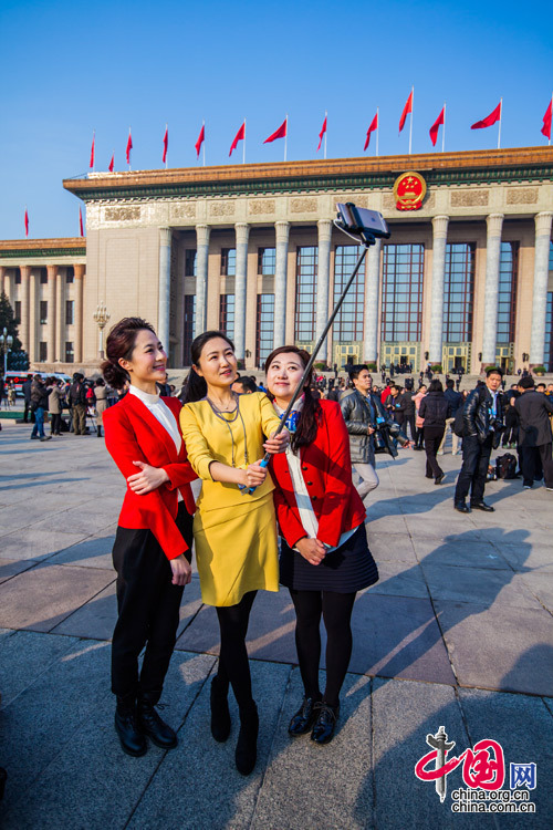 2015年3月5日，第十二届全国人大第三次会议开幕会，三位女记者在人民大会堂前合影留念。中国网 郑亮 摄